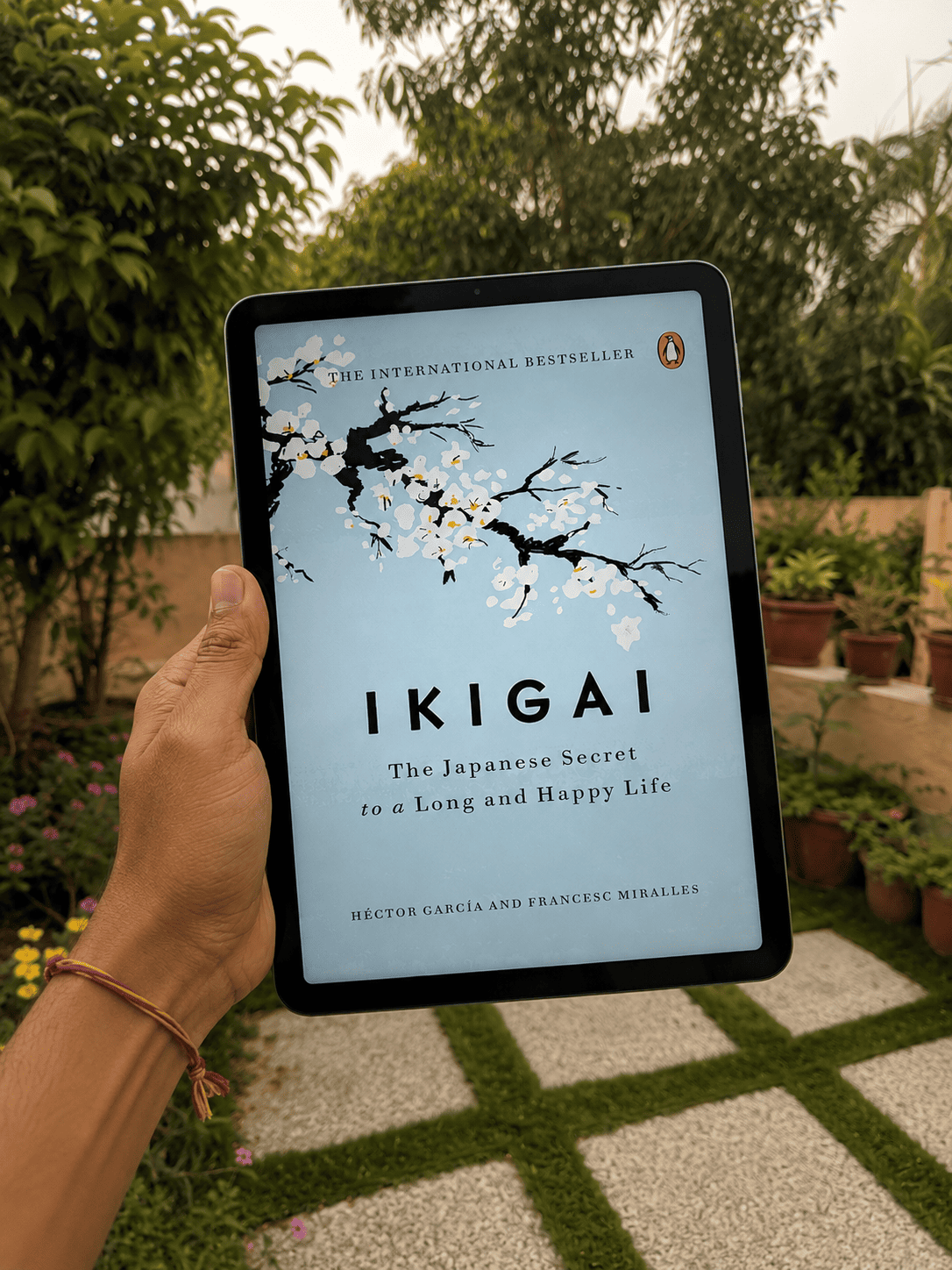 Ikigai cover on a tablet held up in a garden
